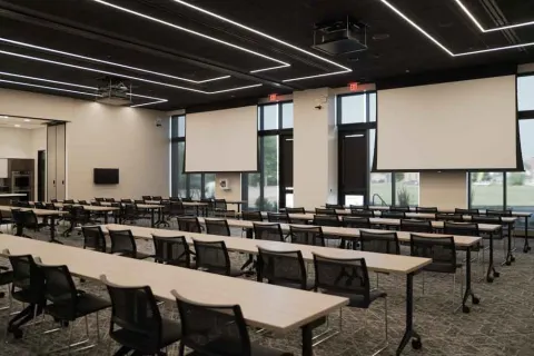 Marion Public Library's Community Room setup, including tables and chairs and projectors and screens. 