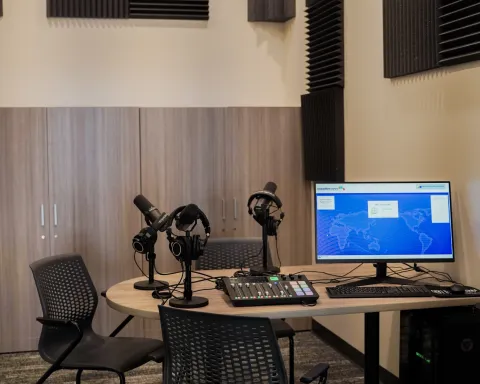 A recording studio with tables, chairs, and recording equipment
